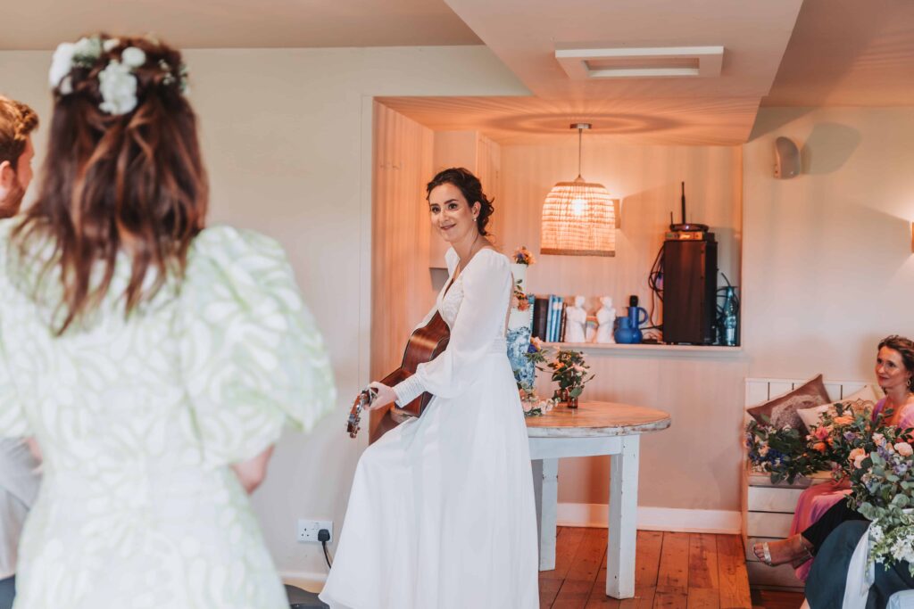 bride singing her vows and playing guitar