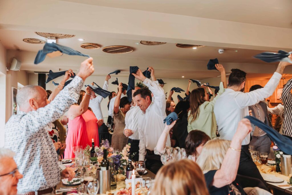 guests cheering as brides enter the room