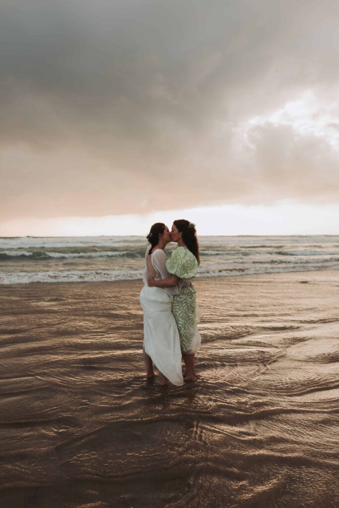 brides kissing in the sea at lgbtq wedding