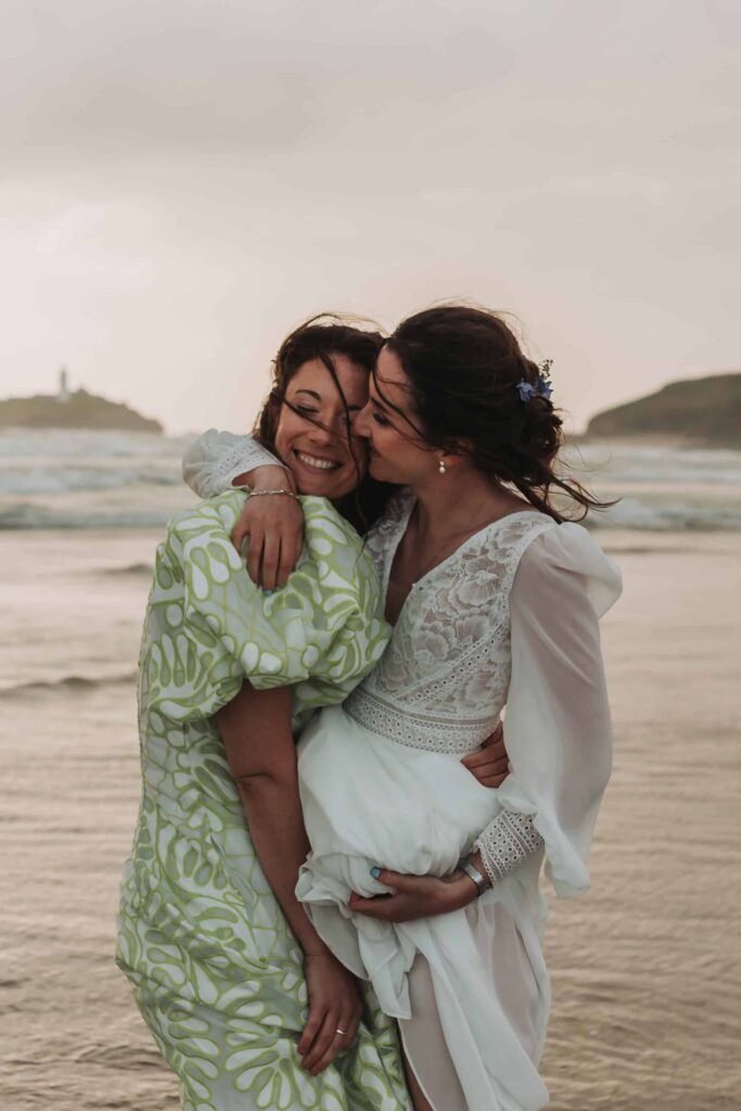 two brides hugging on cornish beach