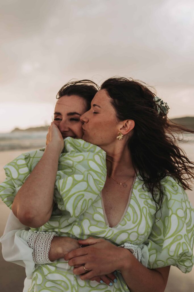 bride kissing her bride on cornish beach