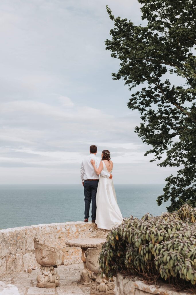 bride and groom looking out to sea at pennsylvania castle estate