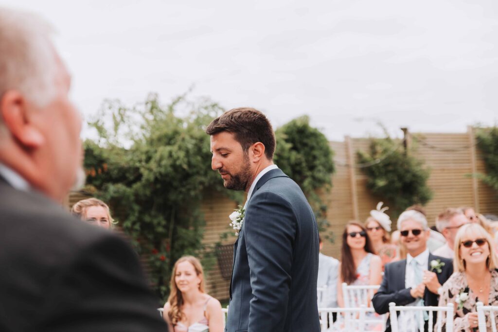 groom waiting at the end of the aisle