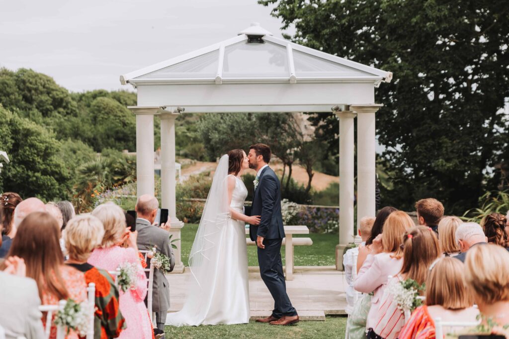 bride and groom sharing first kiss
