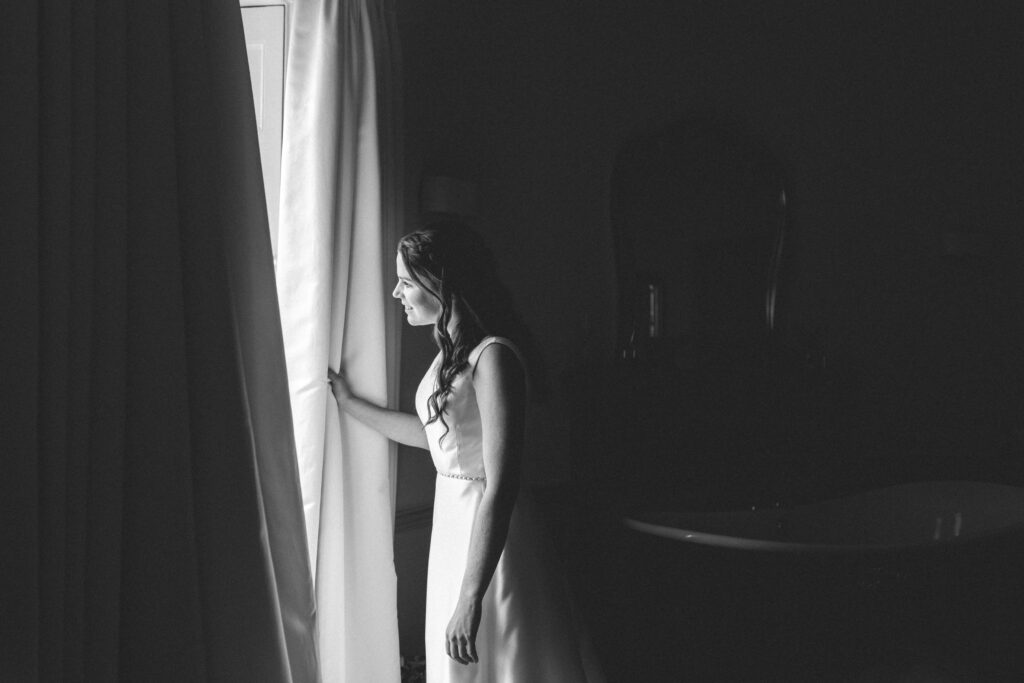 bride looking out of window at pennsylvania castle estate