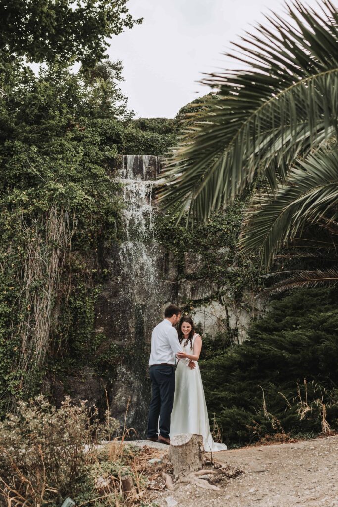 bride at groom stood by a waterfall