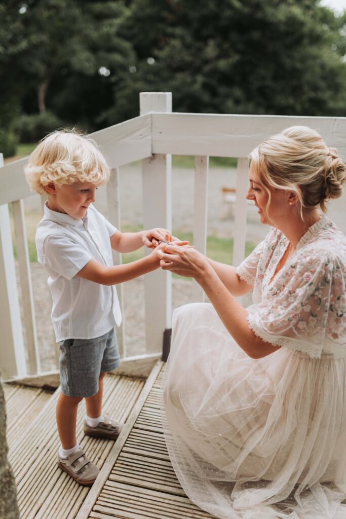 bride putting her sons bracelet on