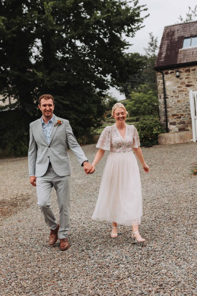 bride and groom walking down the aisle together at countryside eloepement