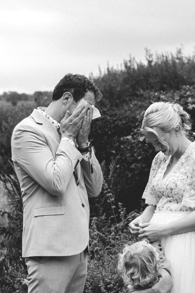 groom drying eyes at countryside elopement