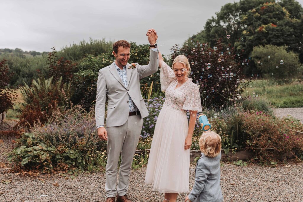 bride and groom celebrating saying i do whilst son blow bubbles