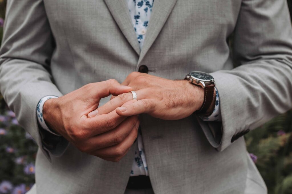 groom adjusting wedding ring