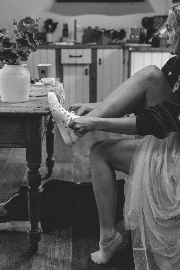 bride putting wedding trainers on