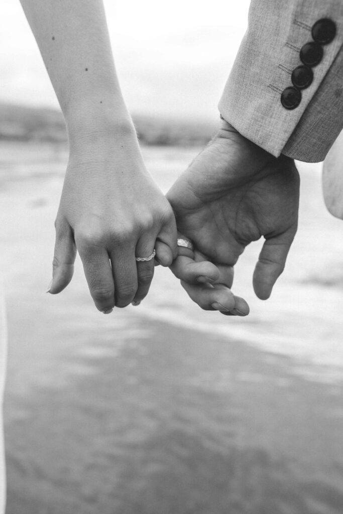 interlinking fingers showing wedding rings on bride and groom