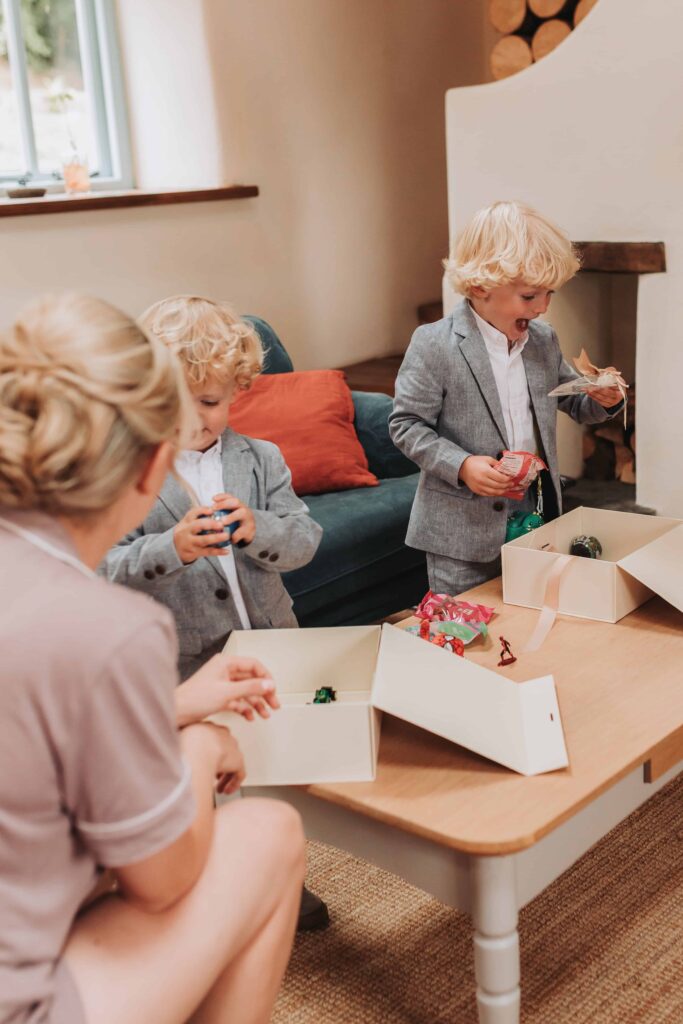two young boys getting gift boxes on parents wedding day
