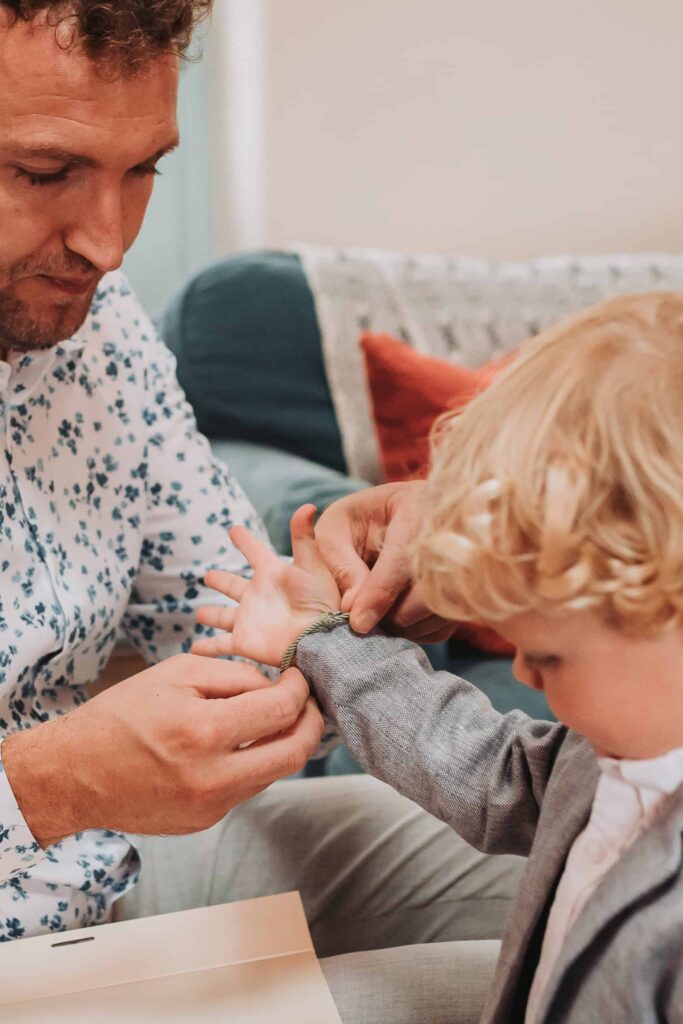 dad putting young sons bracelet on