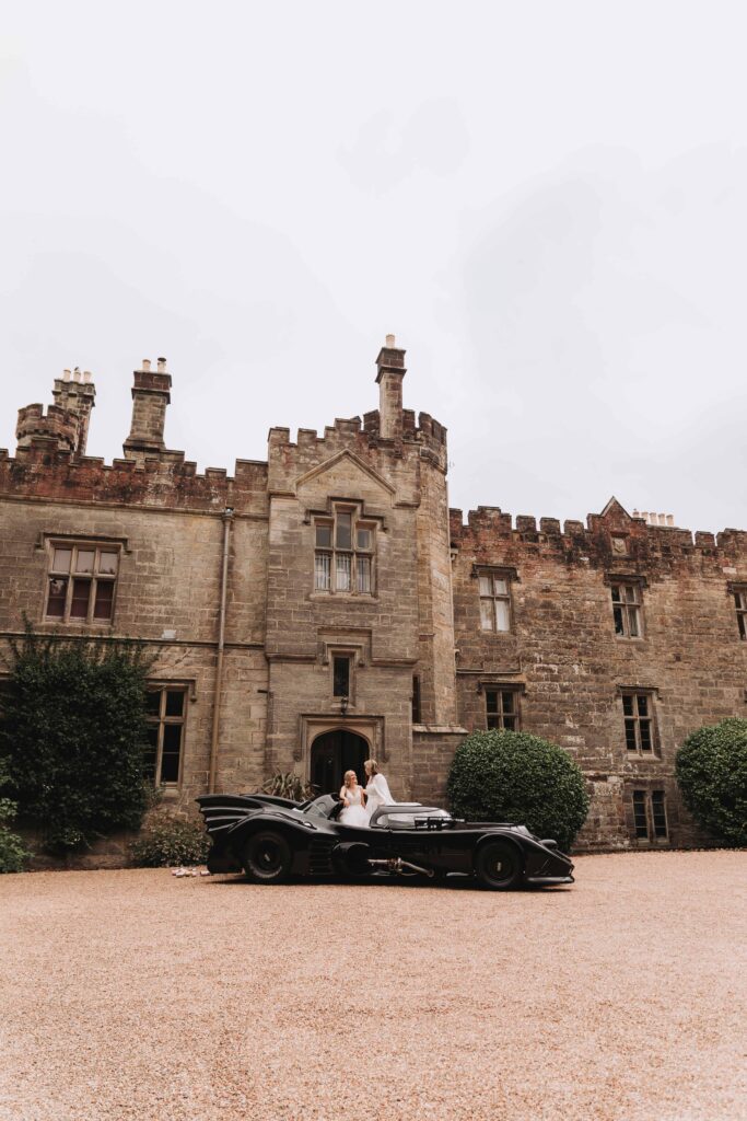 brides stood in batmobile infront of wadhurst castle