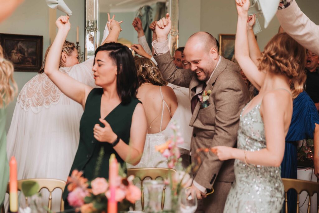 wedding guests cheering two brides into wedding breakfast