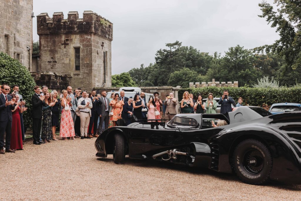 guests watching batmobile arrive at lgbtq wedding