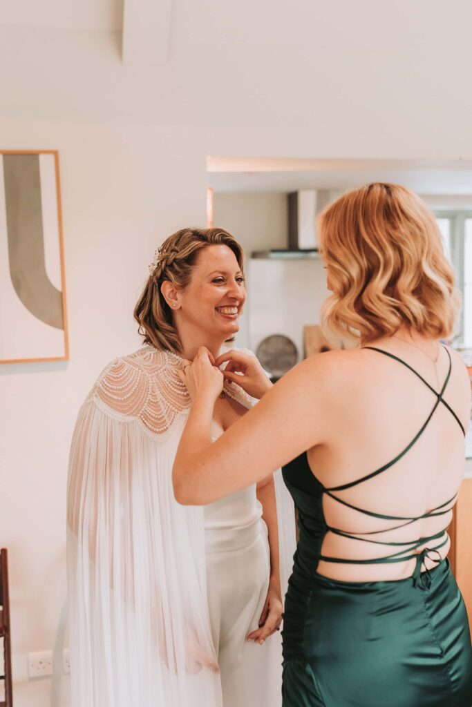 bride putting wedding cape on