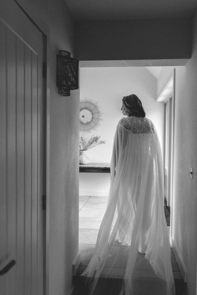 bride walking with wedding cape behind
