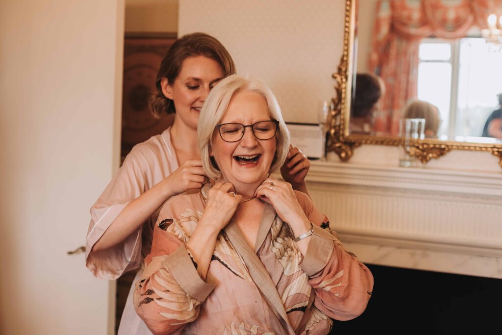 mother of the bride having a necklace put on