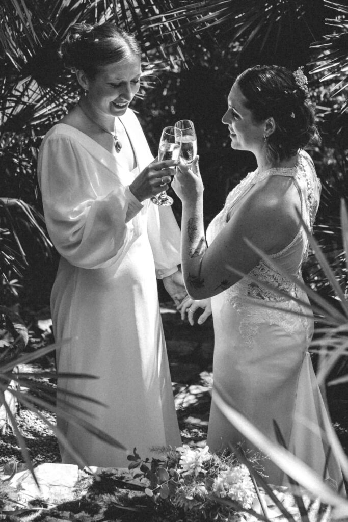 two brides touching champagne glasses