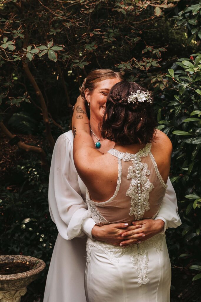 two brides holding eachother in lamorran gardens