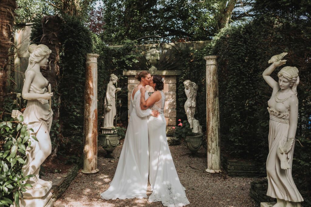 two brides in statue garden at cornwall lgbtq+ wedding