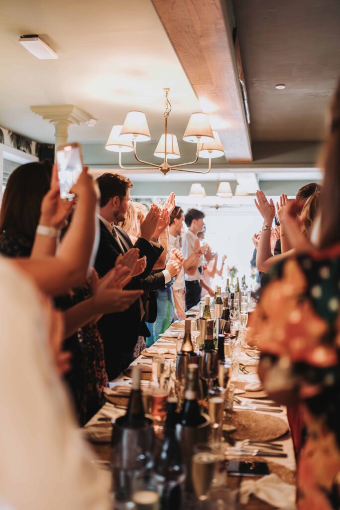 guests clapping bridal entrance to wedding breakfast