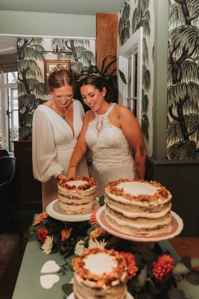 two brides cutting wedding cake