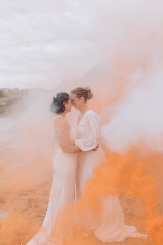 brides surrounded by smoke bombs on st mawes beach