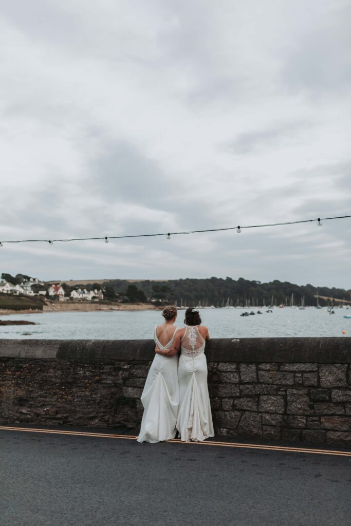 brides looking out at harbour at cornwall lgbtq+ wedding