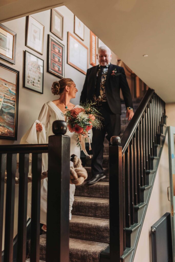 bride walking down stairs on her own at st mawes