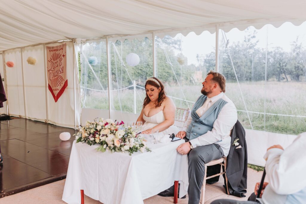 bride and groom listening to speeches
