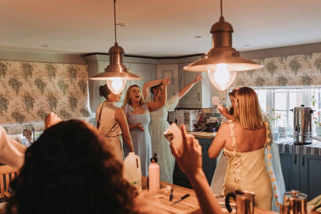 bridal party and bride dancing in the kitchen before ceremony