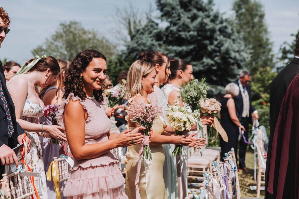 bridesmaids smiling watching wedding ceremony