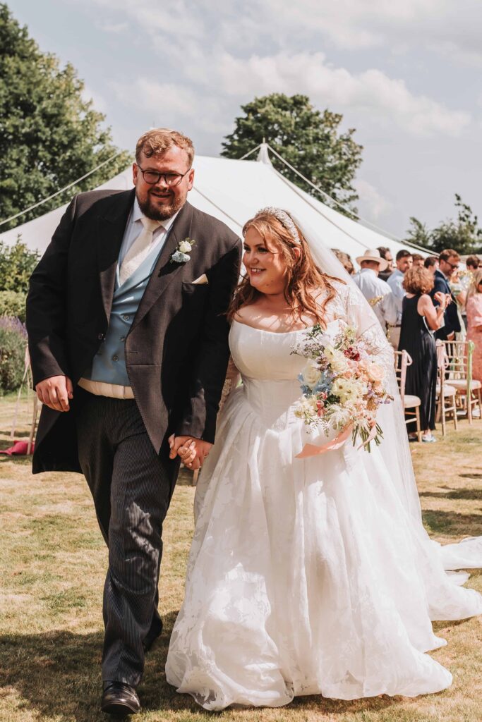 bride and groom walking down the aisle just married