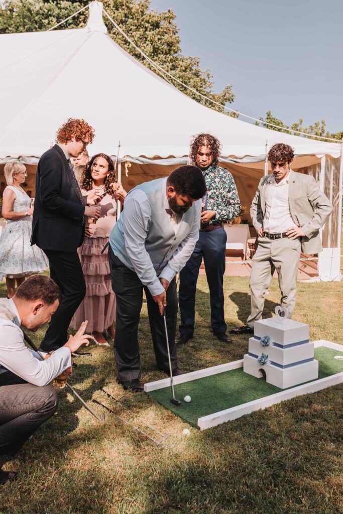 wedding guests playing crazy golf at summer wedding