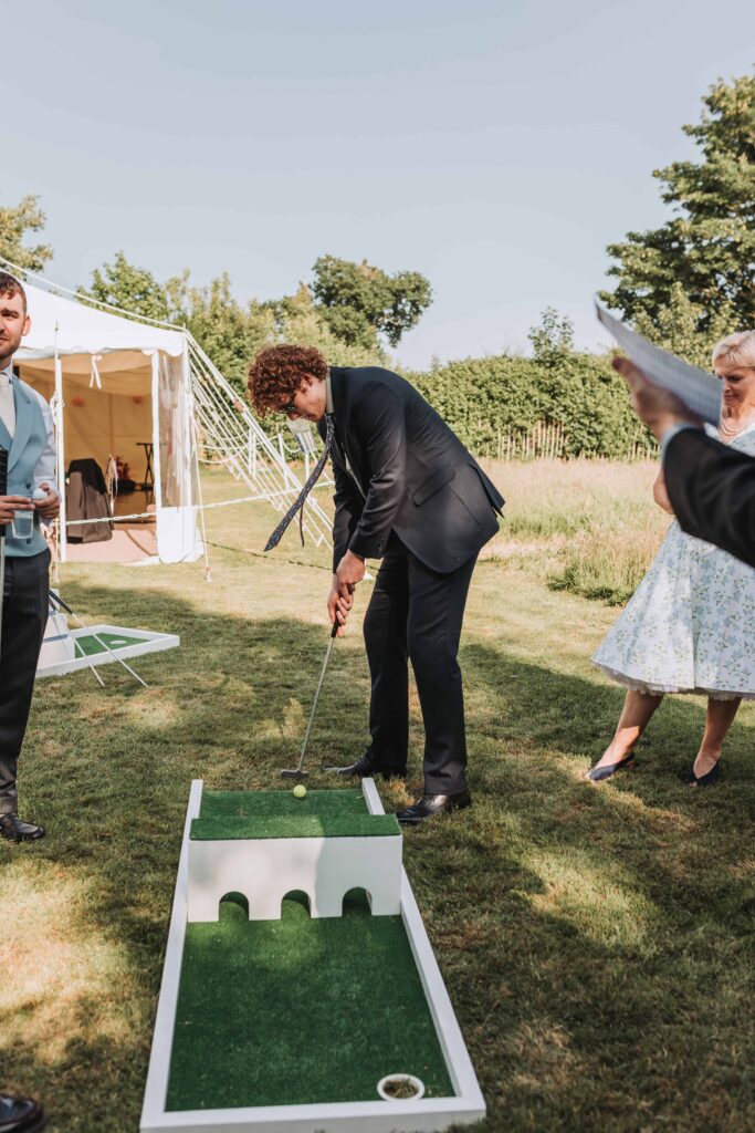 wedding guests playing crazy golf at norfolk garden wedding