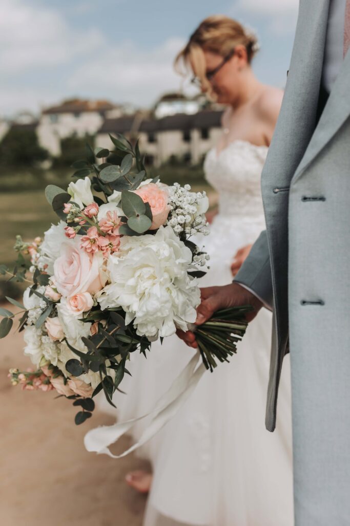 groom holding flower bouquet at wedding