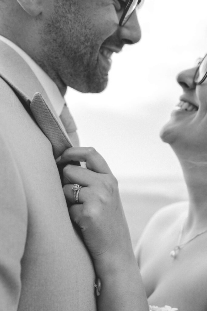 bride holding groom close on holywell beach