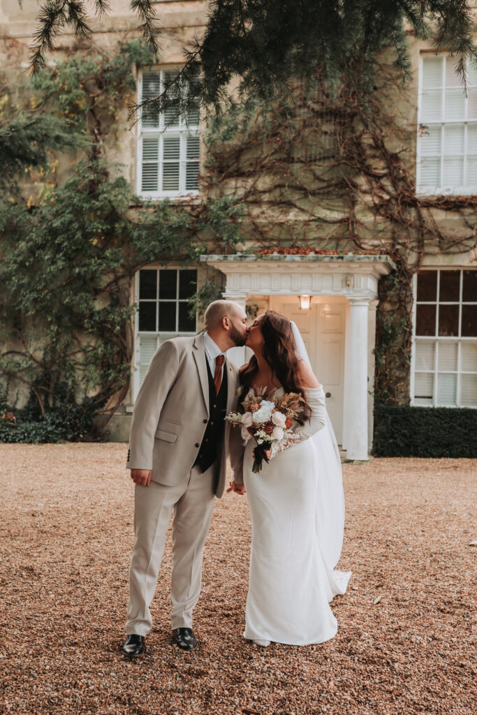 bride and groom kissing outside of north brook park