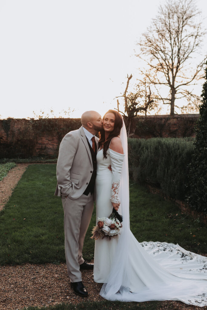 groom kissing brides cheek at northbrook park wedding