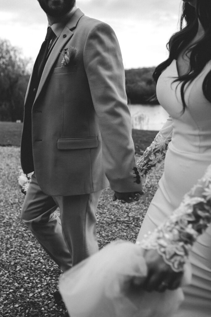 bride and groom walking hand in hand at northbrook park wedding