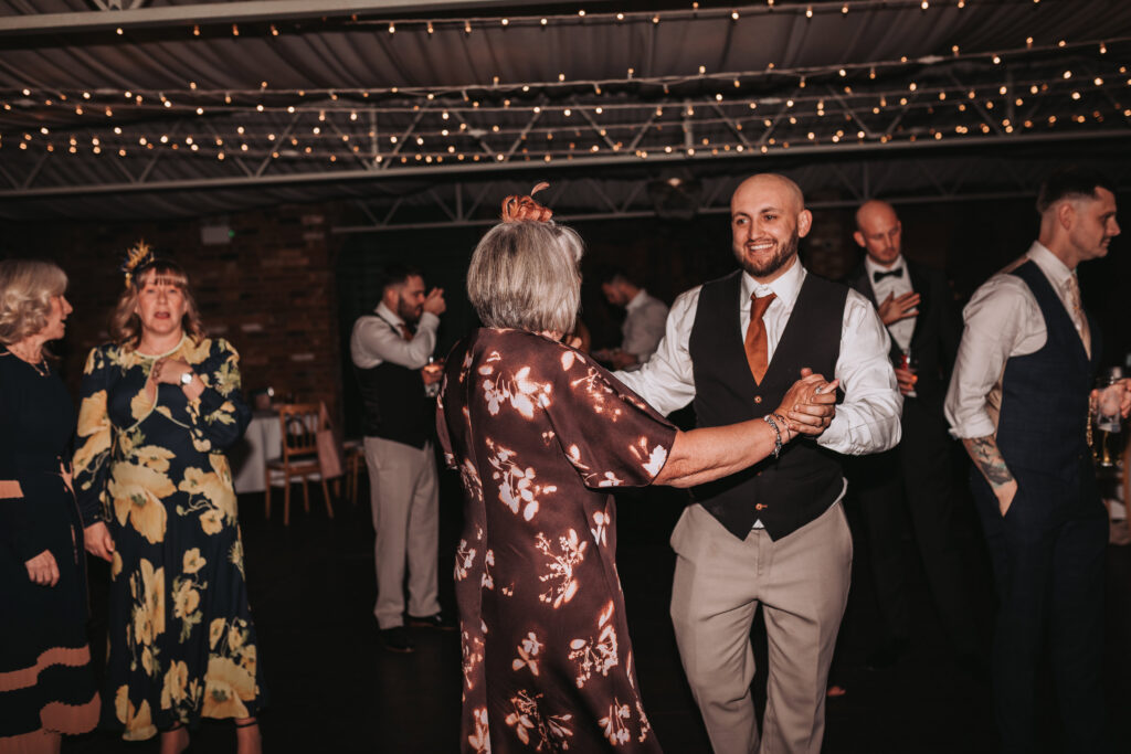 groom dancing with a family member on the dancefloor