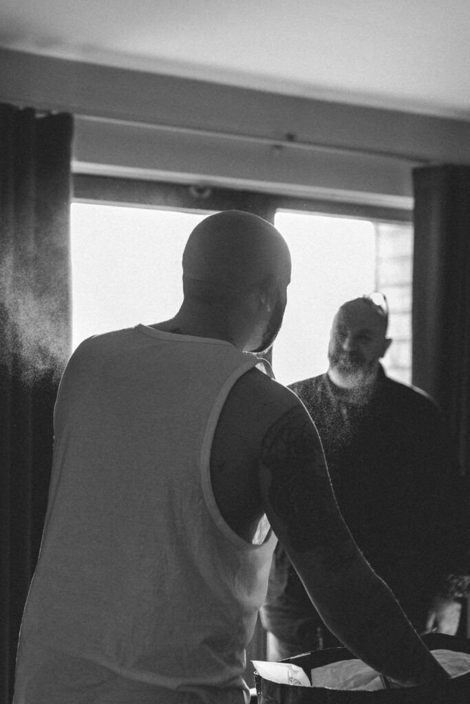 groom spraying aftershave as he is getting ready at northbrook park wedding