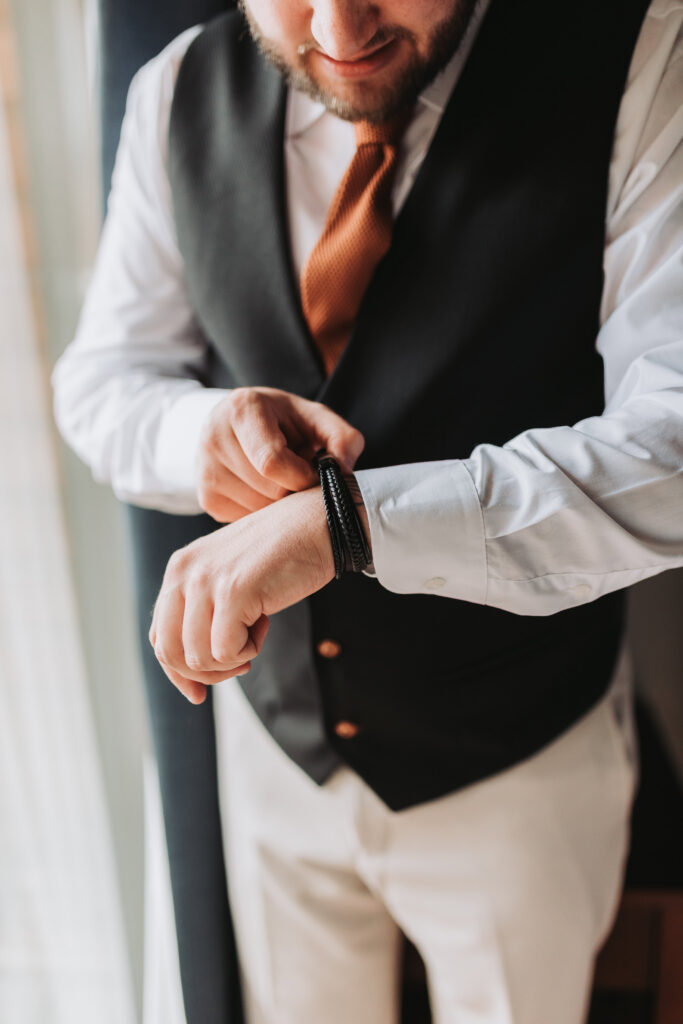 groom adjusting his bracelet getting ready