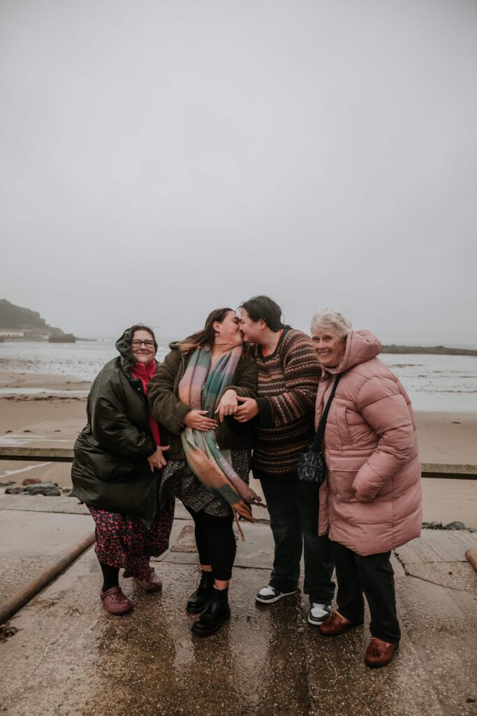 newly engaged couple with mum and granny at surprise proposal