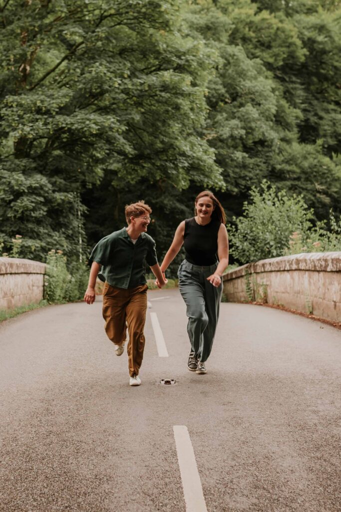 couple running down a road in devon