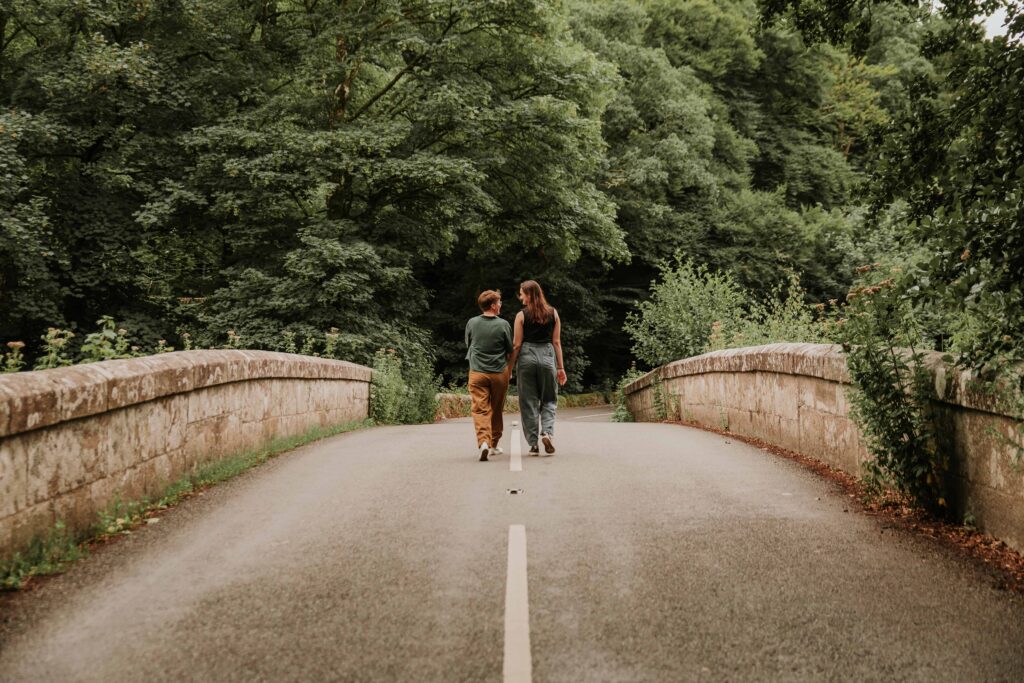 couple standing in the middle of a bridge at surprise proposal